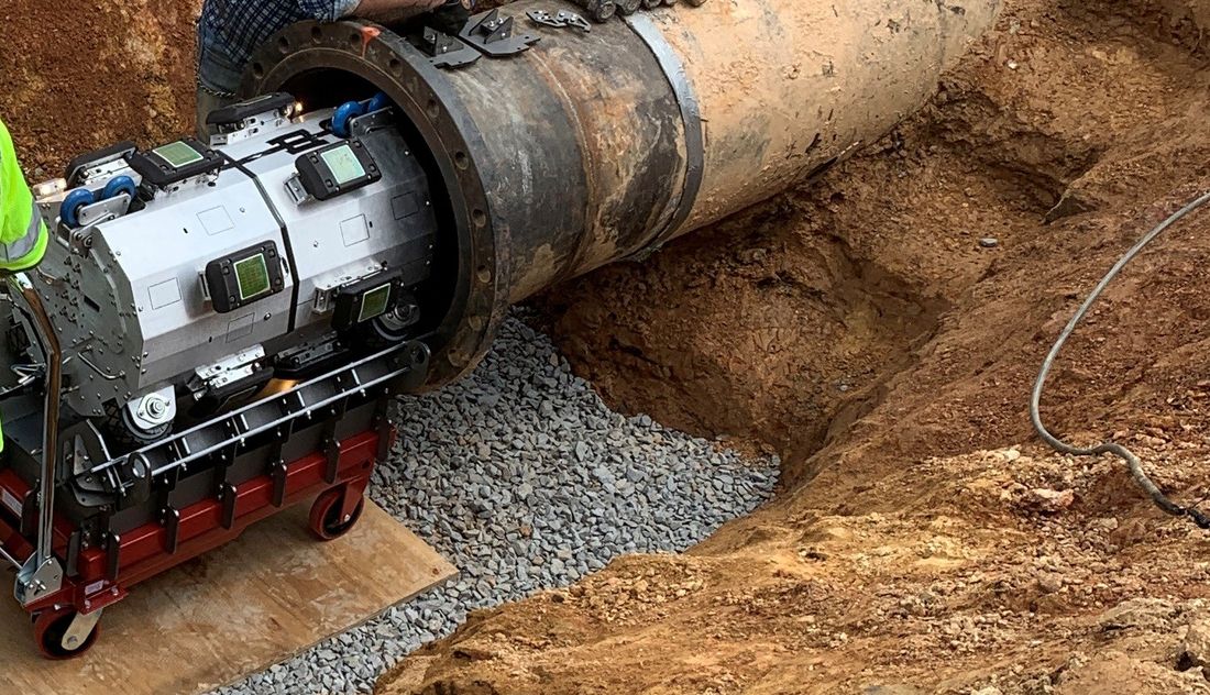 In-line pipeline cleaning and inspection tool entering a pipe during a field trial